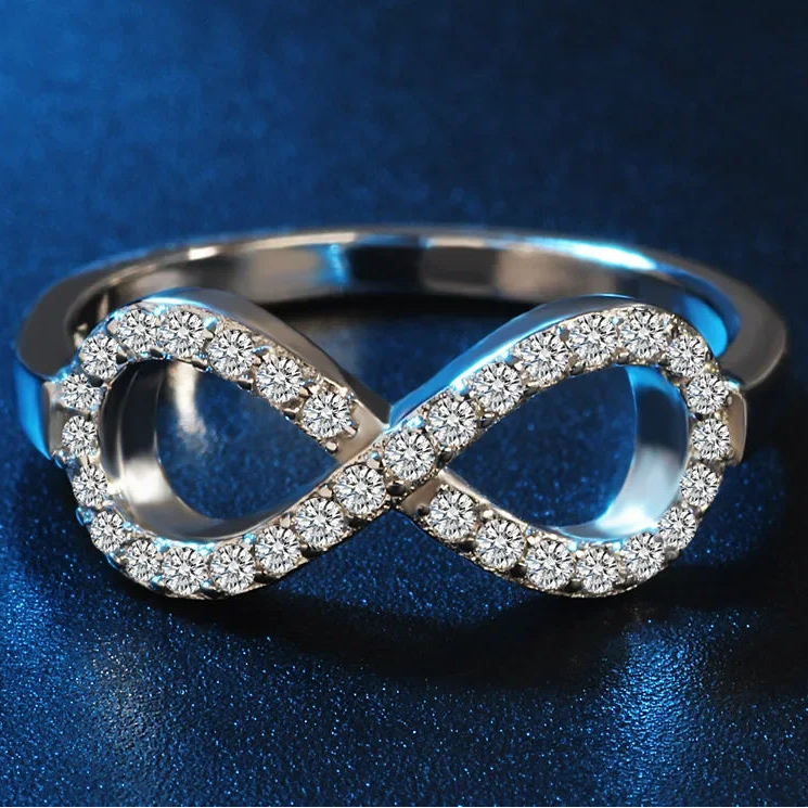 Ring met grafisch ontwerp van een oneindigheidssymbool, versierd met kristallen