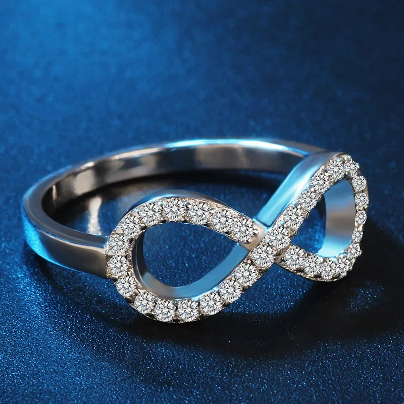 Ring met grafisch ontwerp van een oneindigheidssymbool, versierd met kristallen