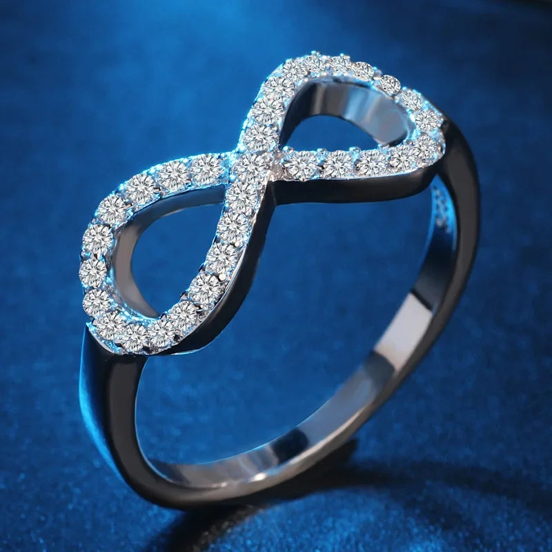 Ring met grafisch ontwerp van een oneindigheidssymbool, versierd met kristallen