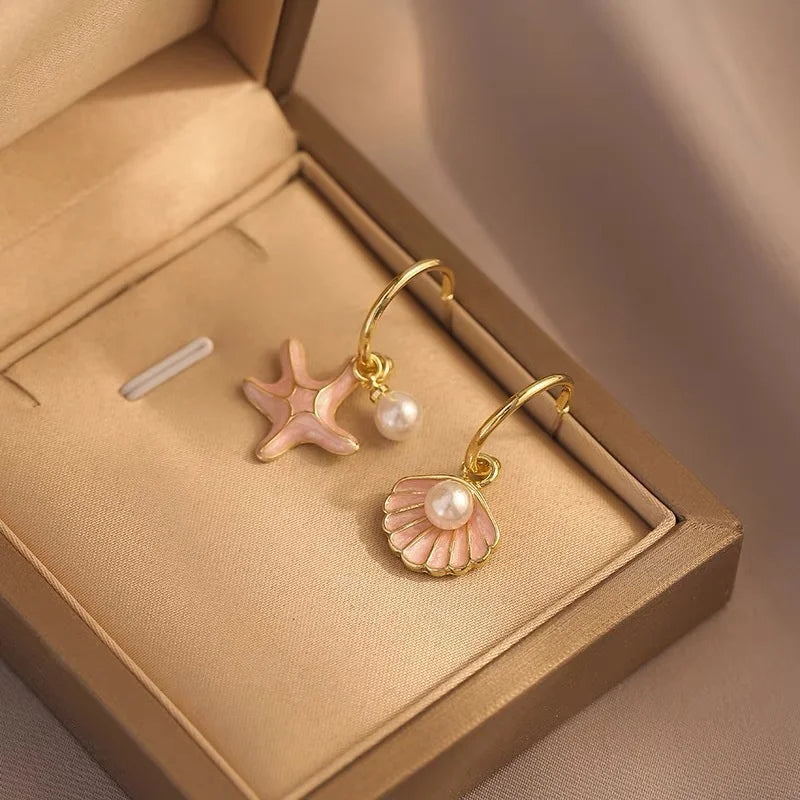 Vergulde oorbellen met schelp en roze parel