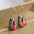 Etnische oorbellen met hun druppelvorm in zilver en rood