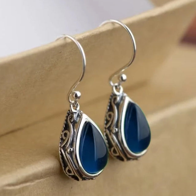 Etnische oorbellen met hun druppelvorm in zilver en blauw