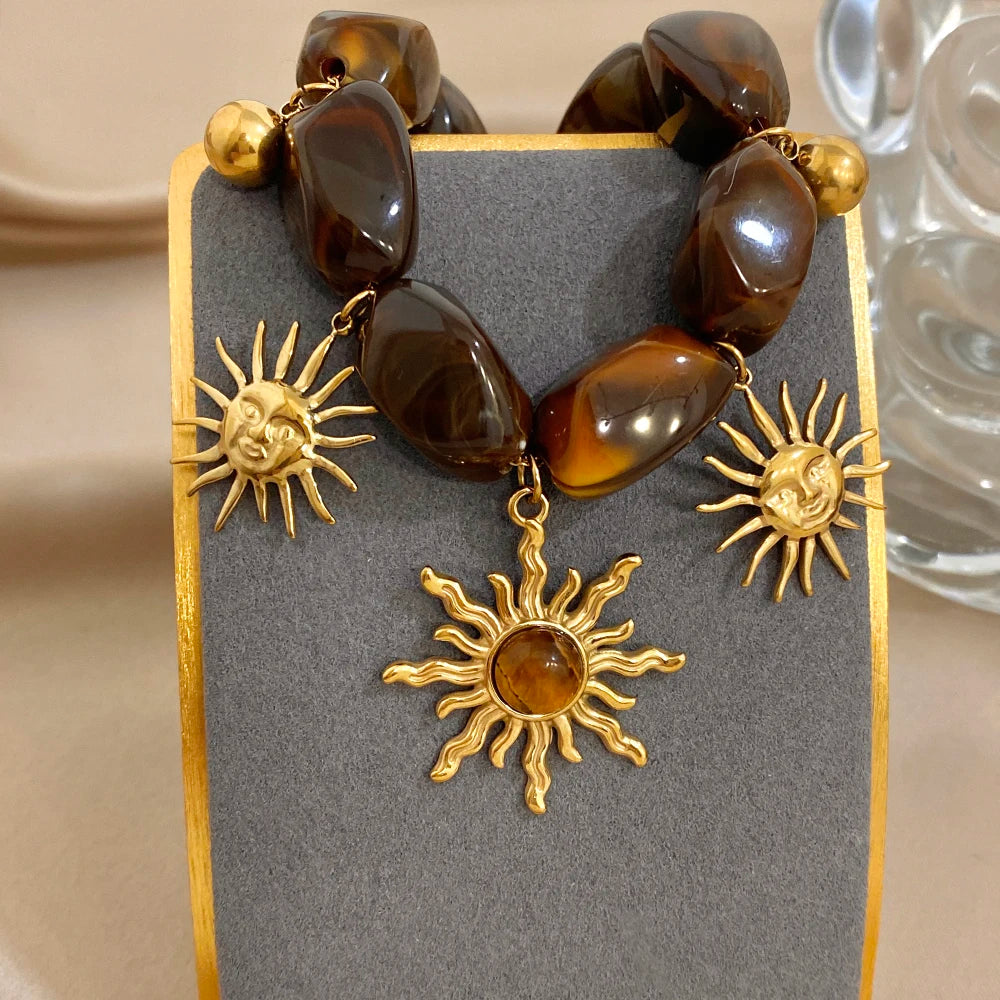 Bracelet bohème avec galets et pendentifs soleils effet oeil de tigre