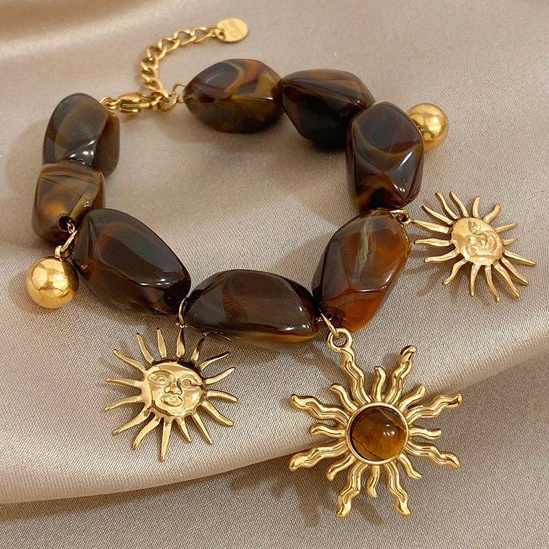 Bracelet bohème avec galets et pendentifs soleils effet oeil de tigre