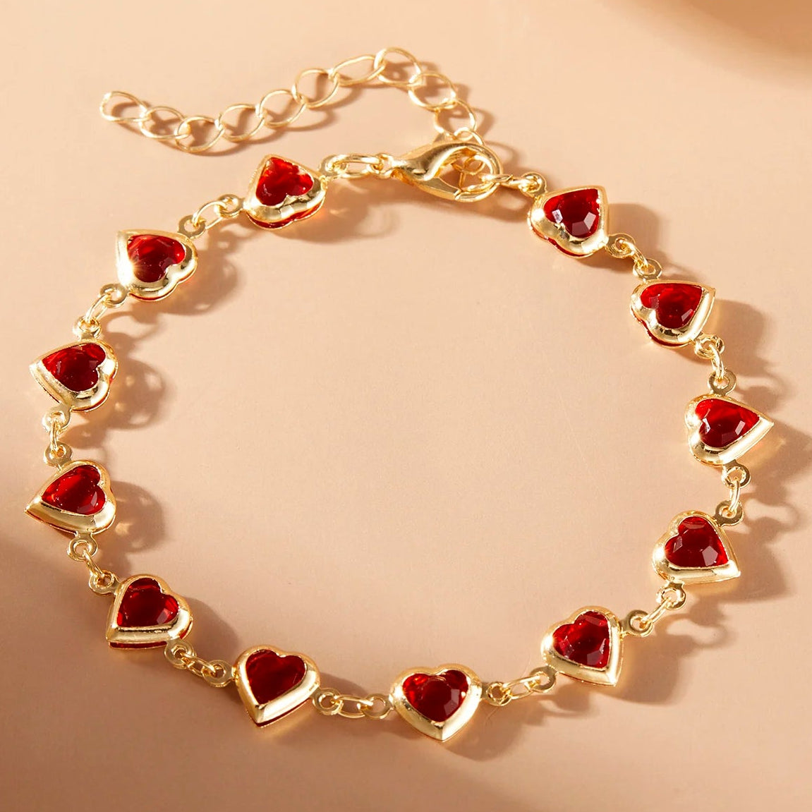 Armband met geëmailleerde hartjes goud en rood