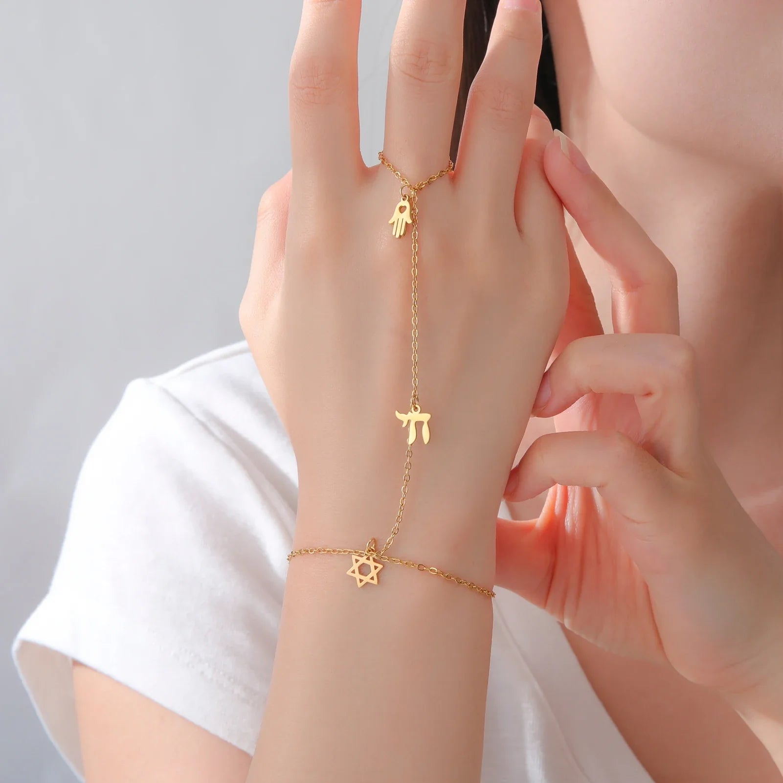 Hand- en vingerarmband met Joodse beschermingshangers Chai, <span data-glossary-id="etoile-de-david">Davidsster</span> en Fatma-hand <span data-glossary-id="etoile">ster</span> goud