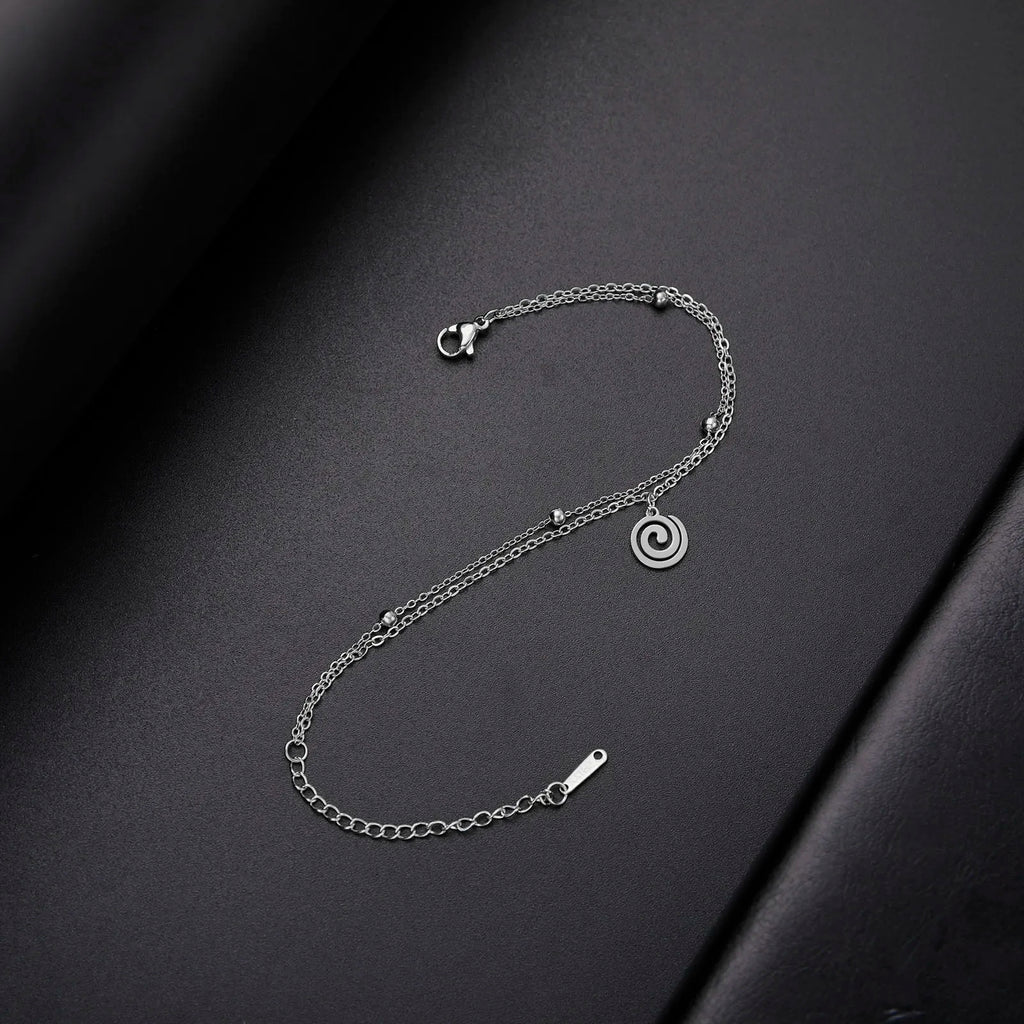 Goudkleurige armband met kleine zilveren spiraalbedel