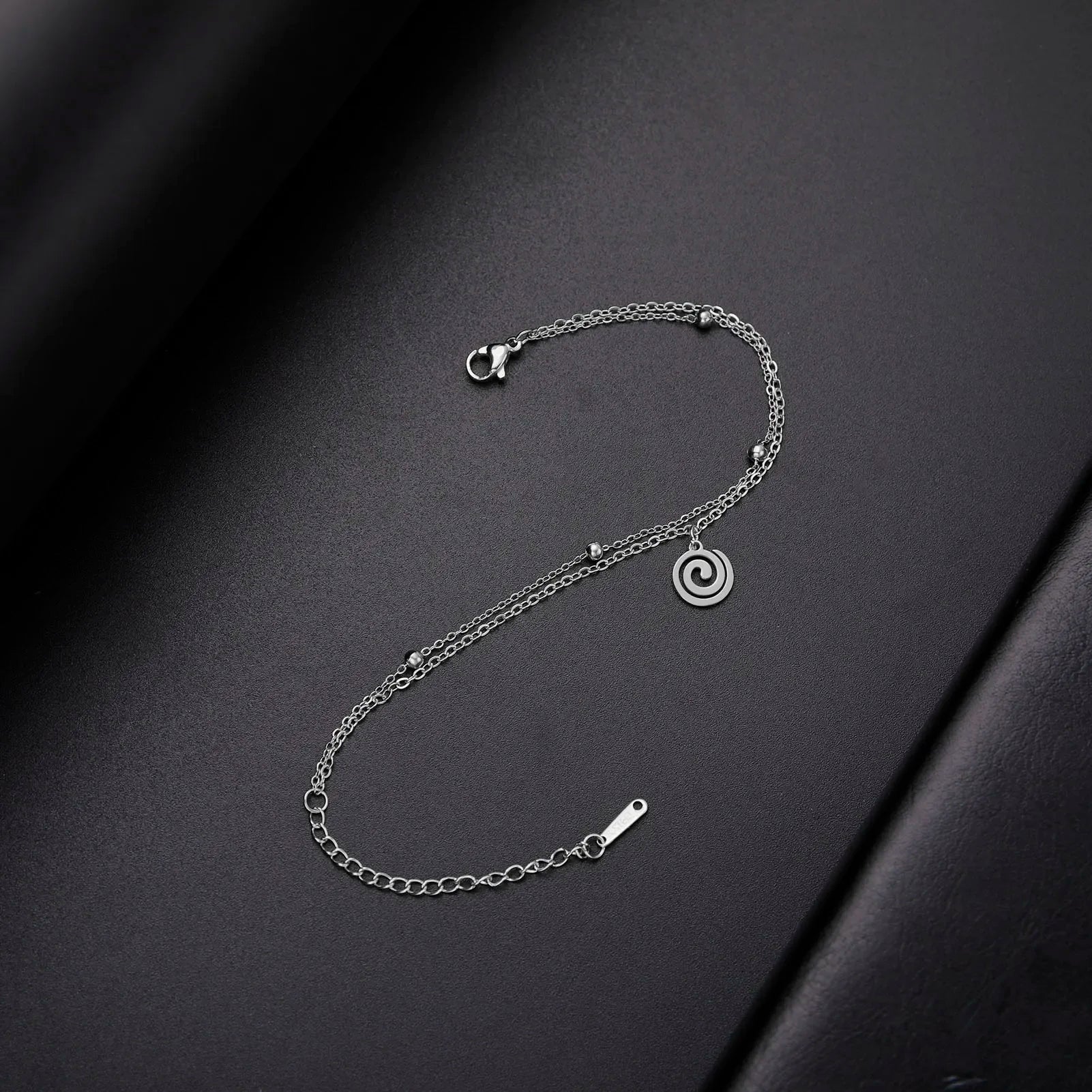 Goudkleurige armband met kleine zilveren spiraalbedel
