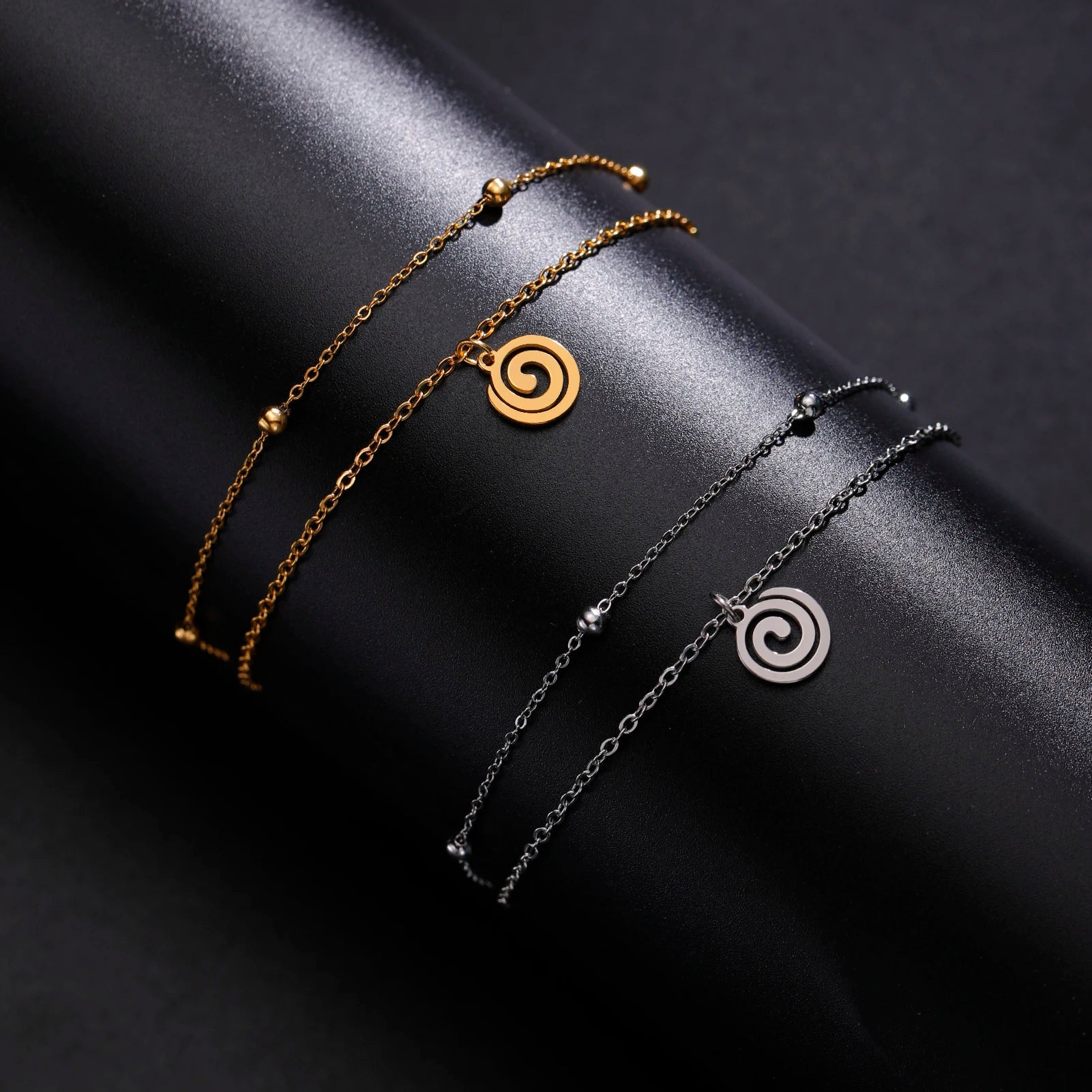 Goudkleurige armband met kleine zilveren spiraalbedel
