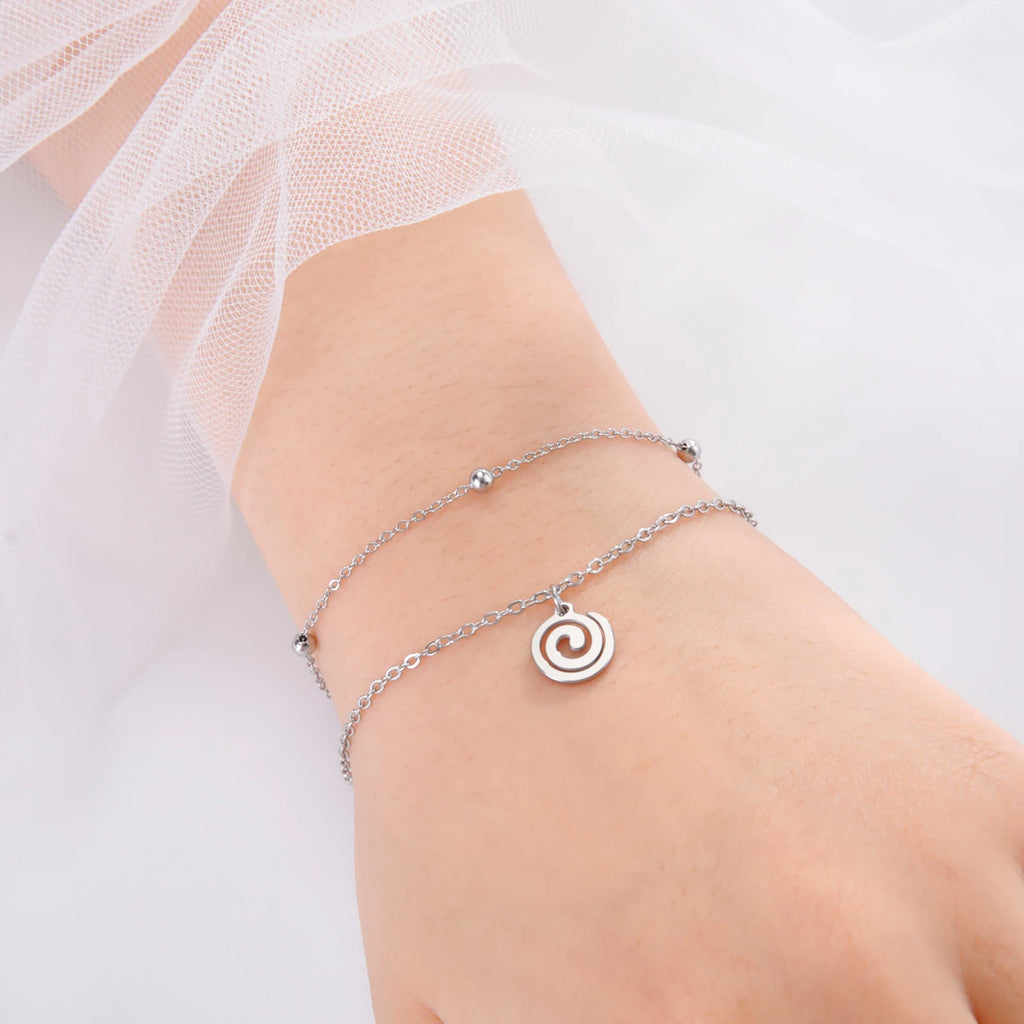 Goudkleurige armband met kleine zilveren spiraalbedel