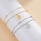 Goudkleurige armband met kleine gouden spiraalbedel