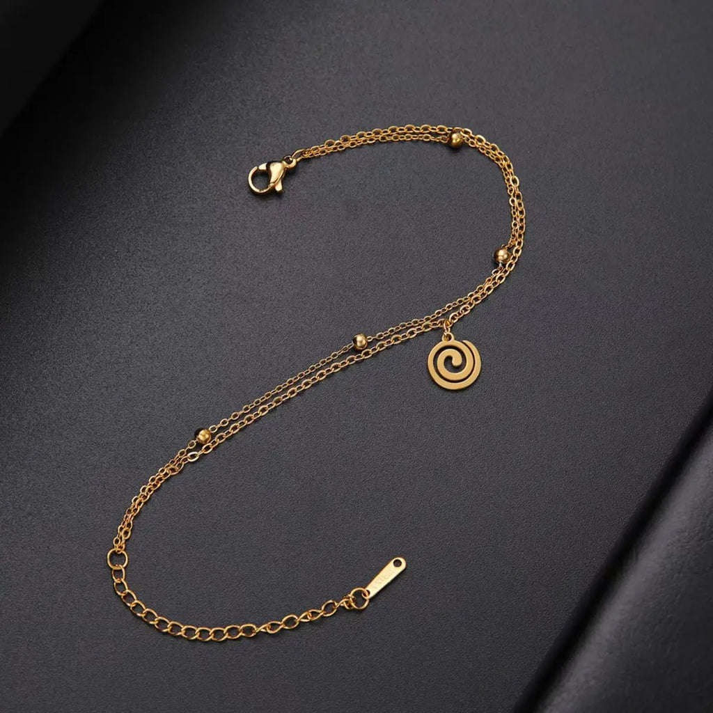 Goudkleurige armband met kleine gouden spiraalbedel
