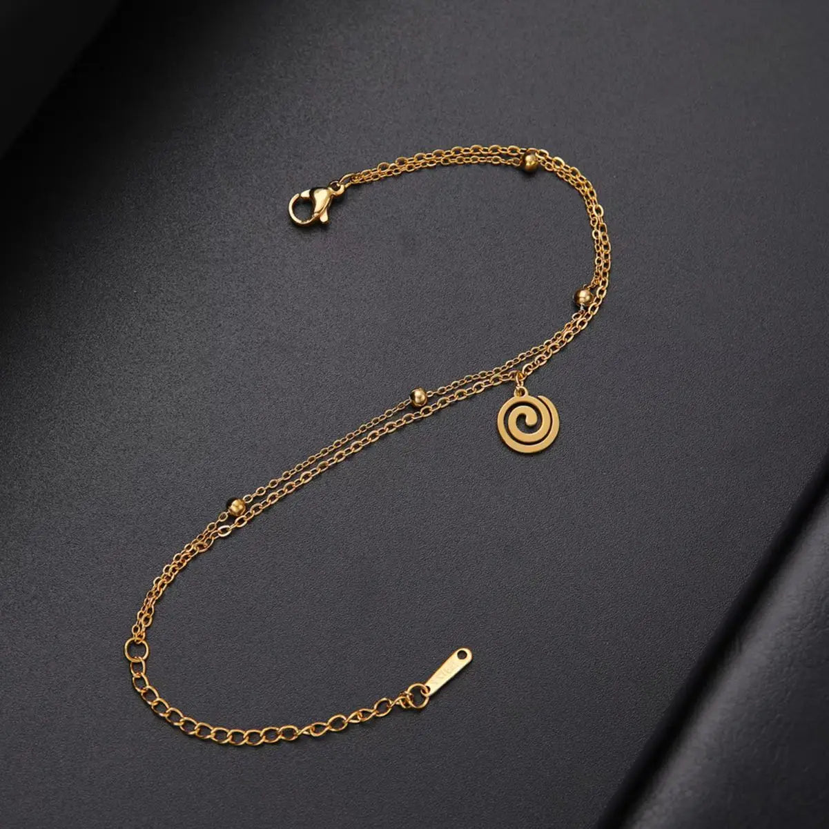 Goudkleurige armband met kleine gouden spiraalbedel