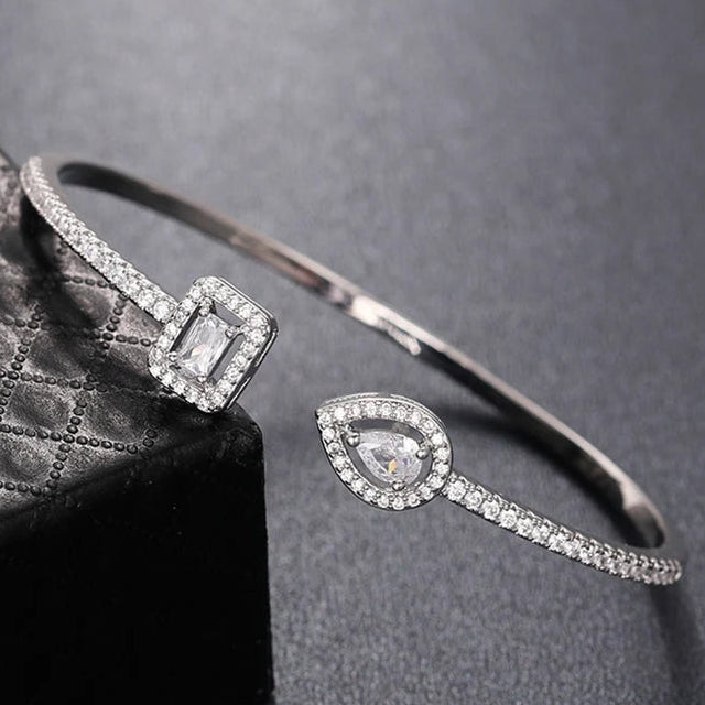 Açık uçlu, strass pavé ve damla şeklinde kristal taşlı gümüş ve beyaz bileklik
