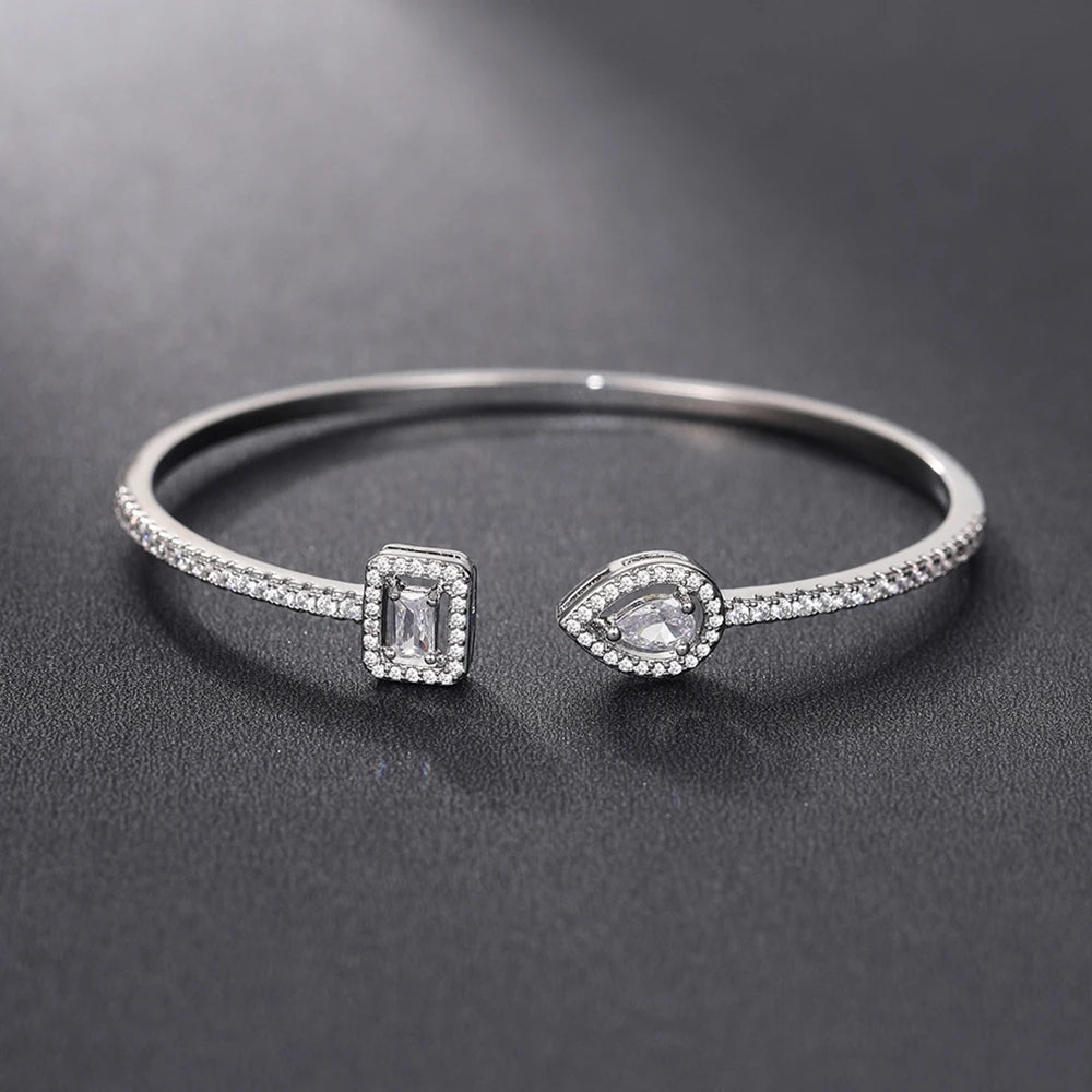 Açık uçlu, strass pavé ve damla şeklinde kristal taşlı gümüş ve beyaz bileklik