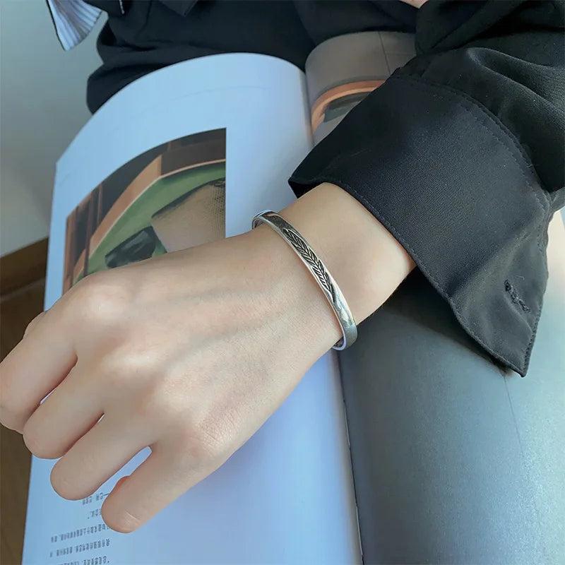 Open manchette armband met zilverkleurige veer