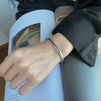 Open manchette armband met zilverkleurige veer