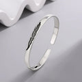 Open manchette armband met zilverkleurige veer
