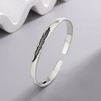 Open manchette armband met zilverkleurige veer