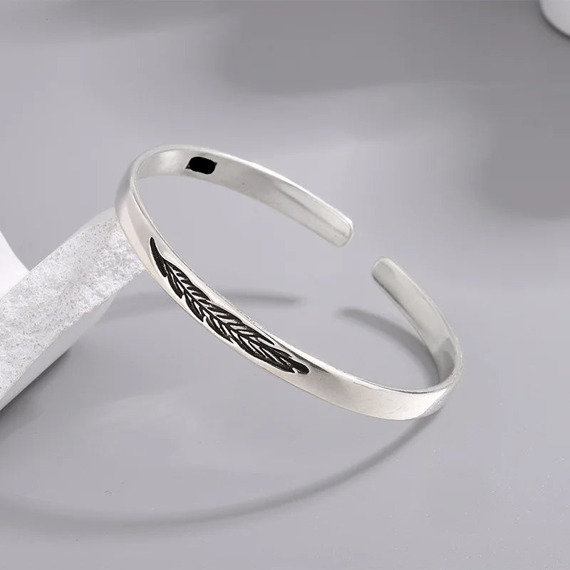 Open manchette armband met zilverkleurige veer