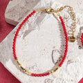 Rode en goudkleurige koraalarmband