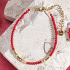 Rode en goudkleurige koraalarmband