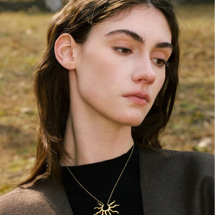 Collier avec grand pendentif demi-soleil aux rayons ondulés 