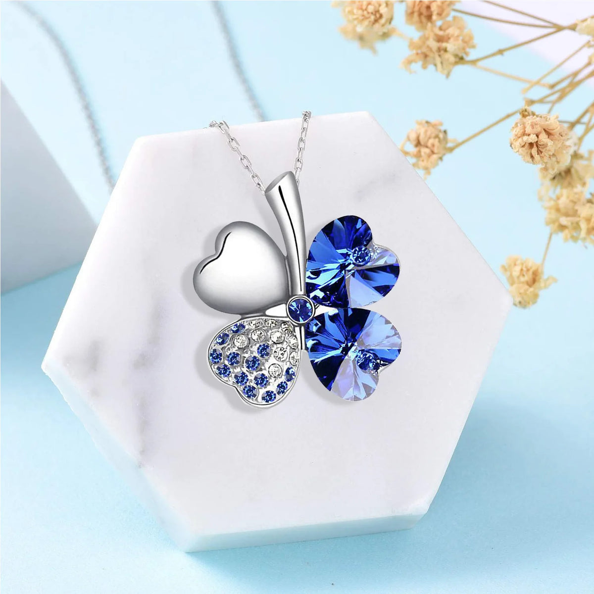 Ketting met grote klavervormige hanger met vier harten in donkerblauw gekleurde kristallen