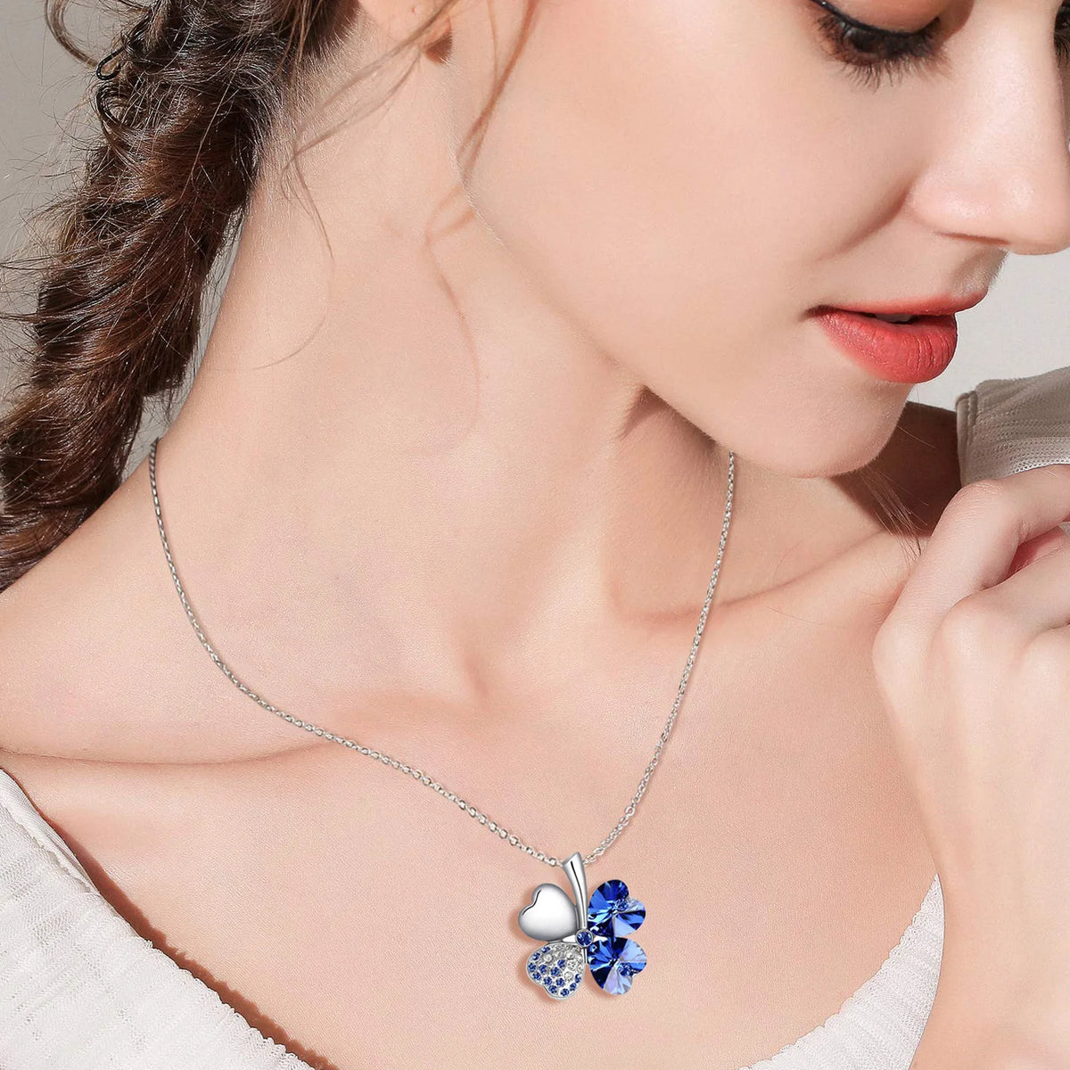 Ketting met grote klavervormige hanger met vier harten in donkerblauw gekleurde kristallen