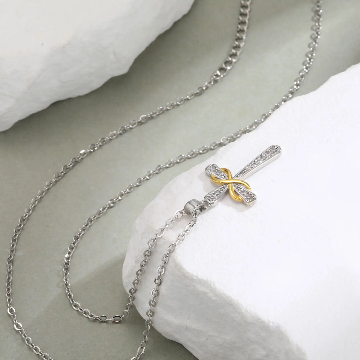 Ketting met hanger in de vorm van een kruis en tweekleurig oneindigheidssymbool