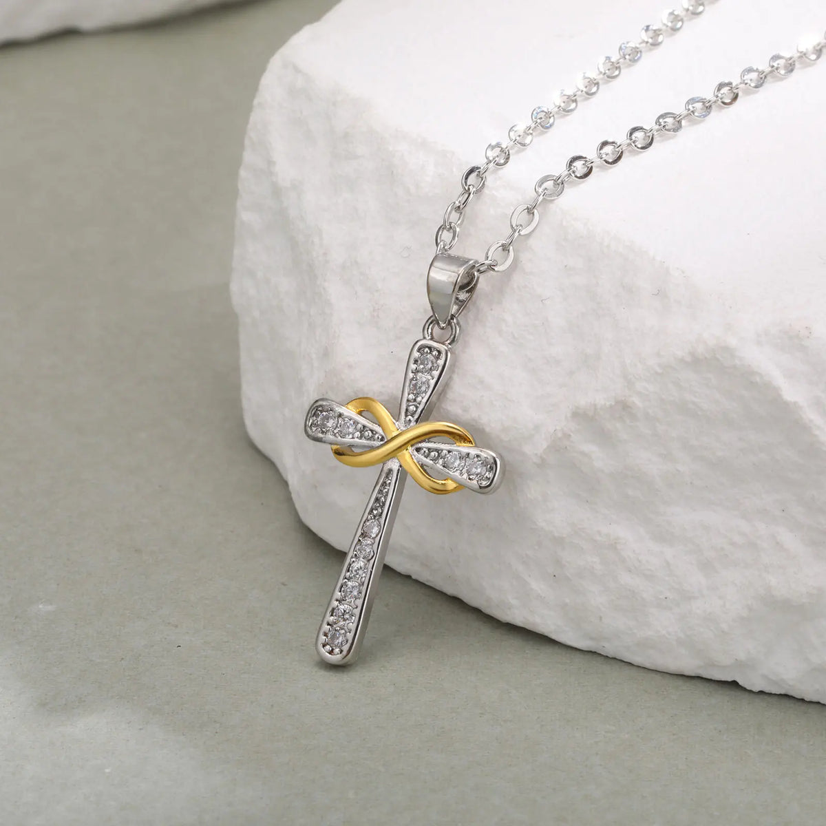 Ketting met hanger in de vorm van een kruis en tweekleurig oneindigheidssymbool