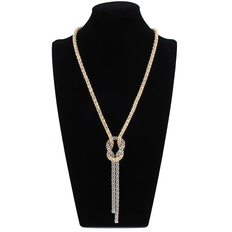 Lange ketting met knoop-hanger in goud en zilver