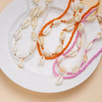Dubbele ketting met kaurischelp rood